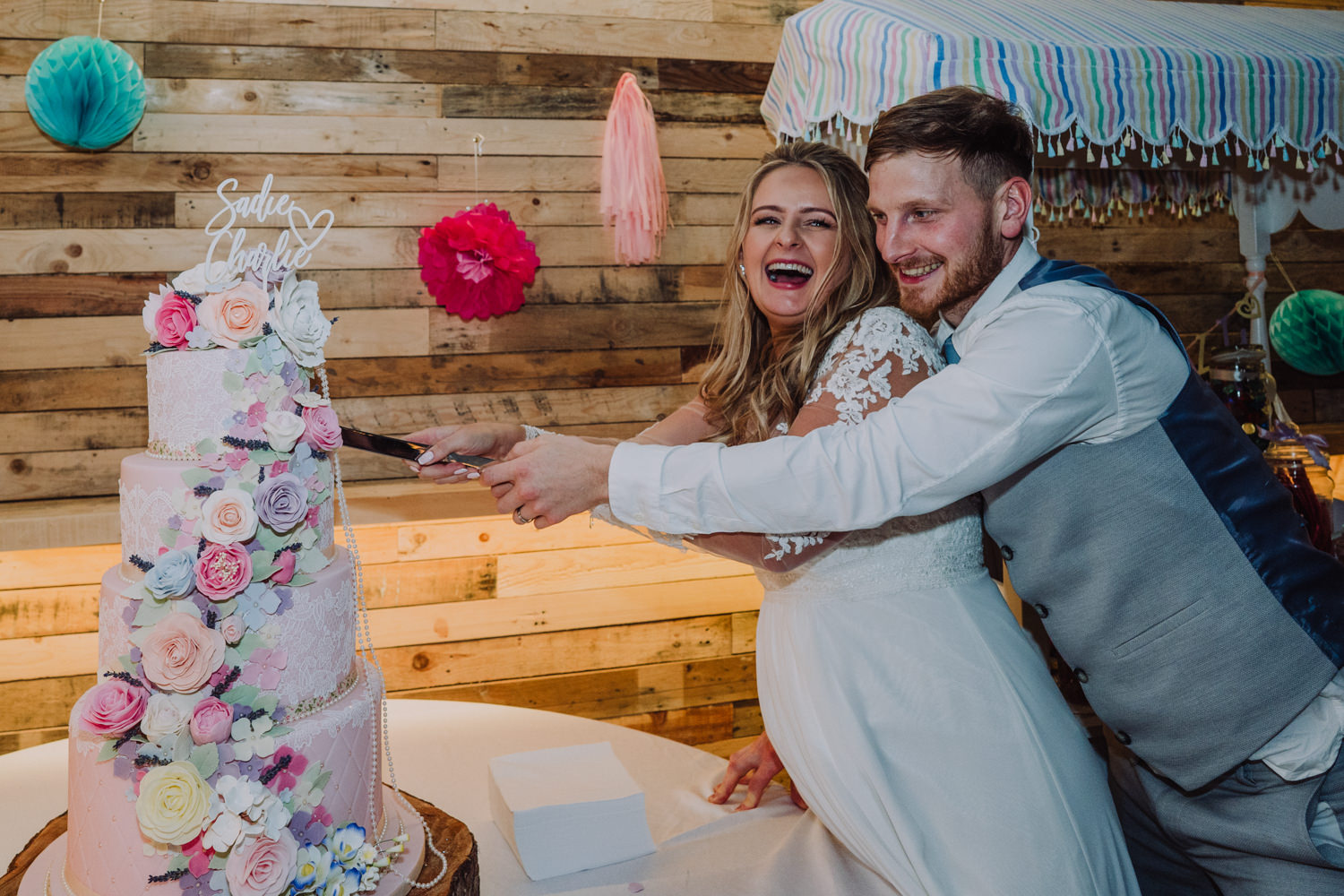 laughing bride and groom cutting the cake at ashbarton estate in north devon