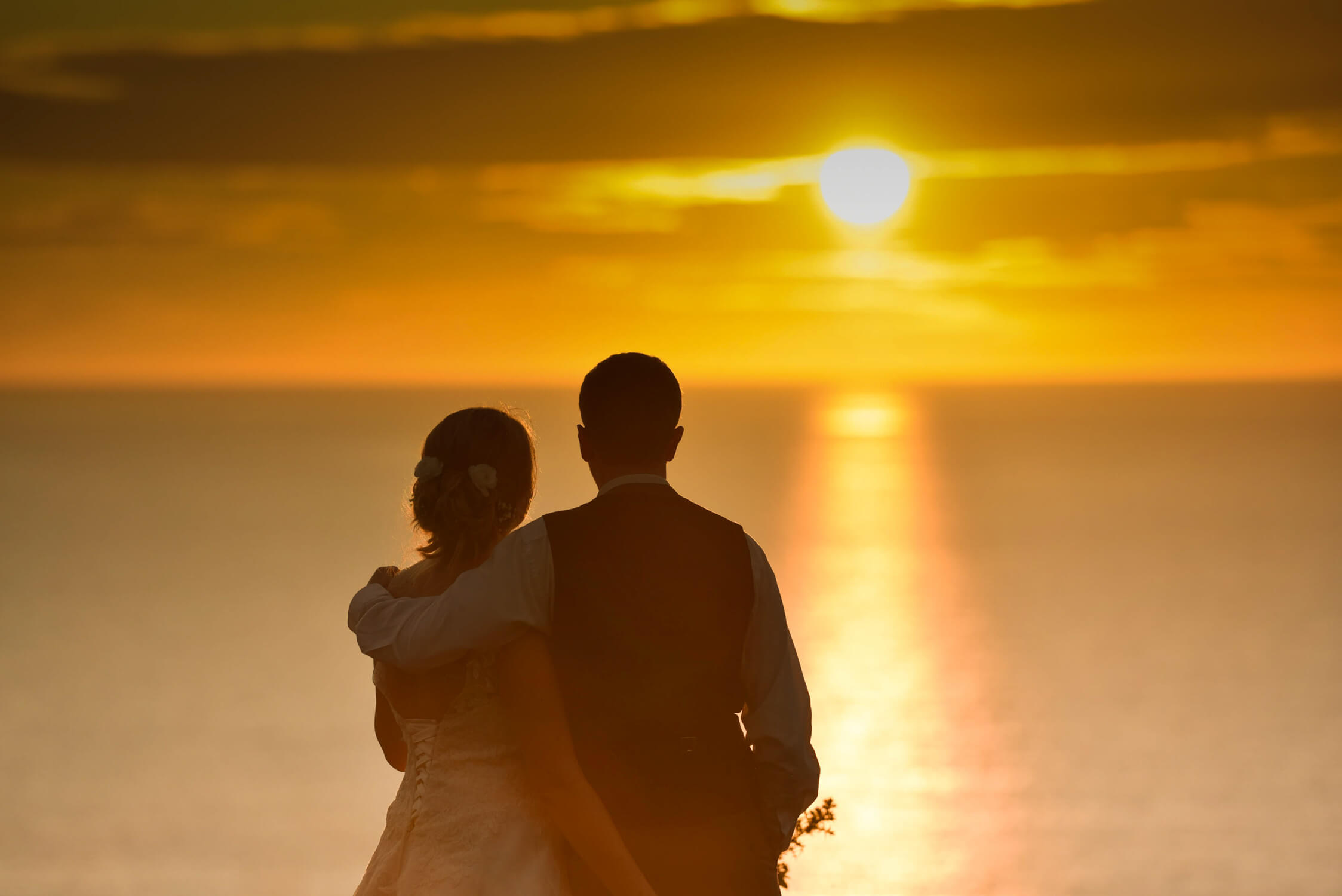 Bride & groom enjoying sunset at ocean Kave westward Ho! Ocean Cave, Devon wedding photographer