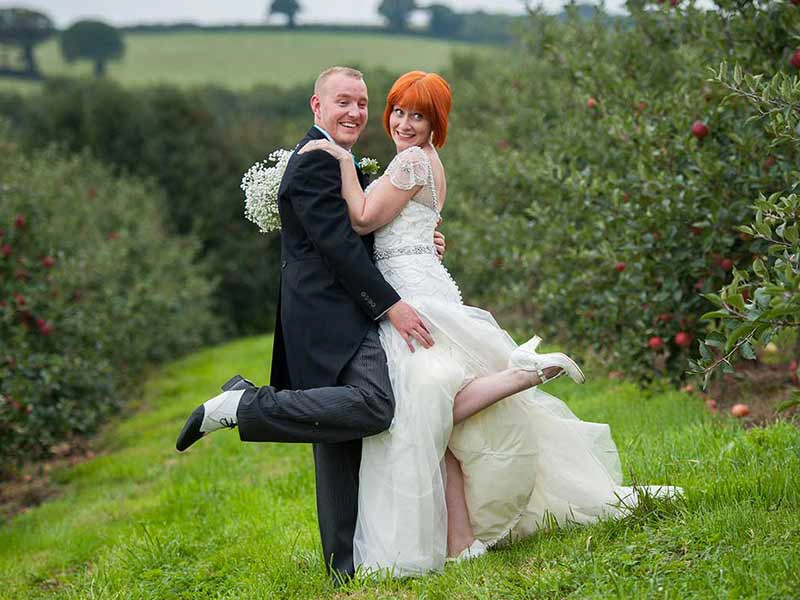 bride and groom in the orchard at the cornbarn in devon